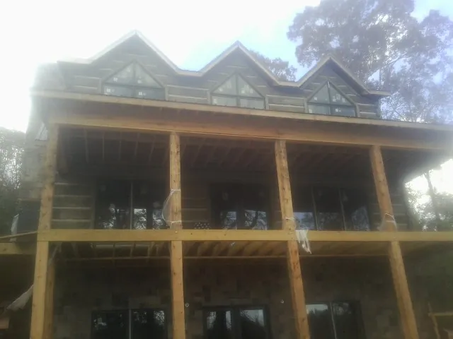 Dormers and porch framing on a large log home under construction — Roof Coating work by our crew in Mokelumne Hill